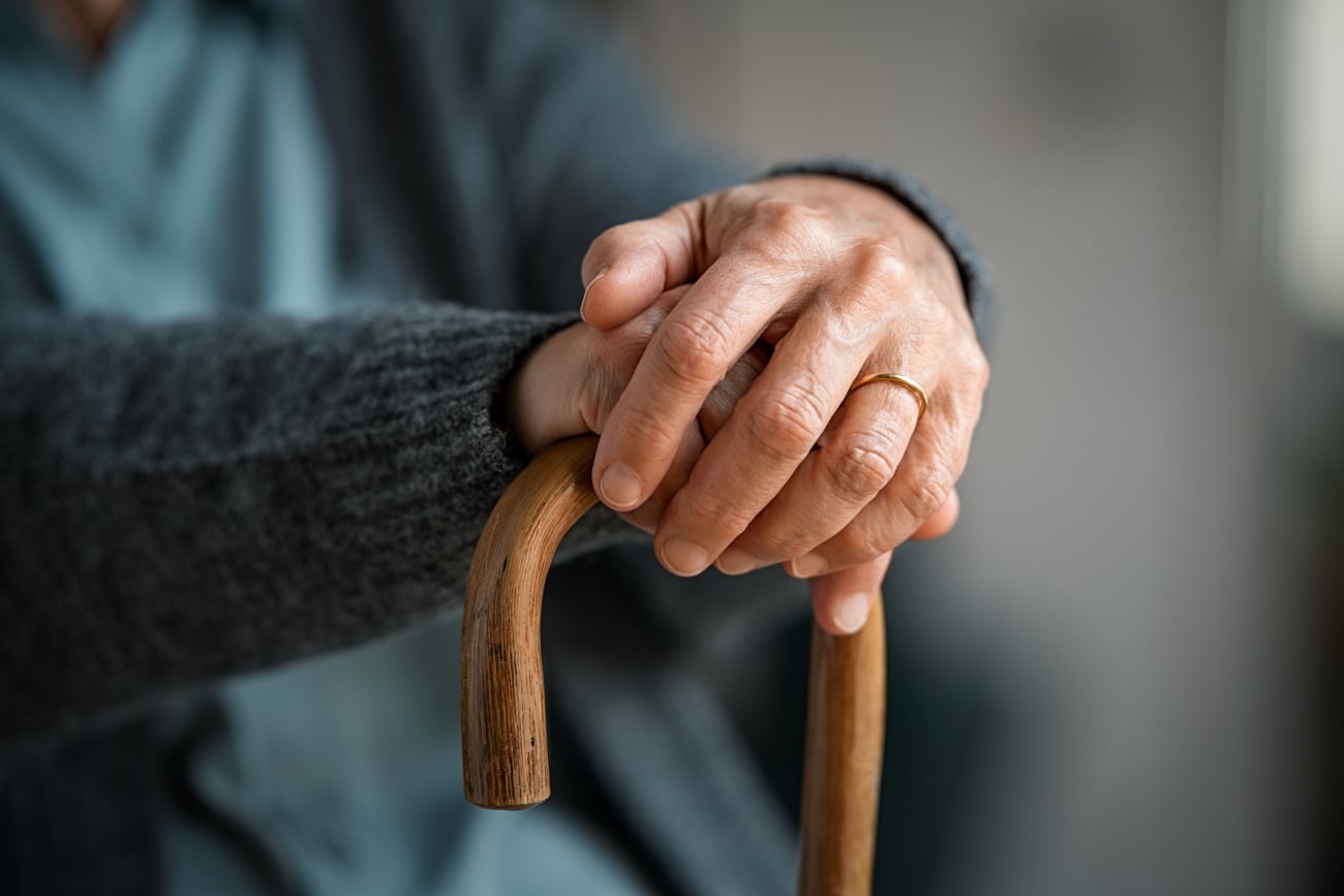 Close,up,of,senior,disabled,woman,hands,holding,walking,stick.